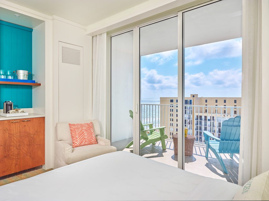 Room part with armchair, large window and balcony with partial views