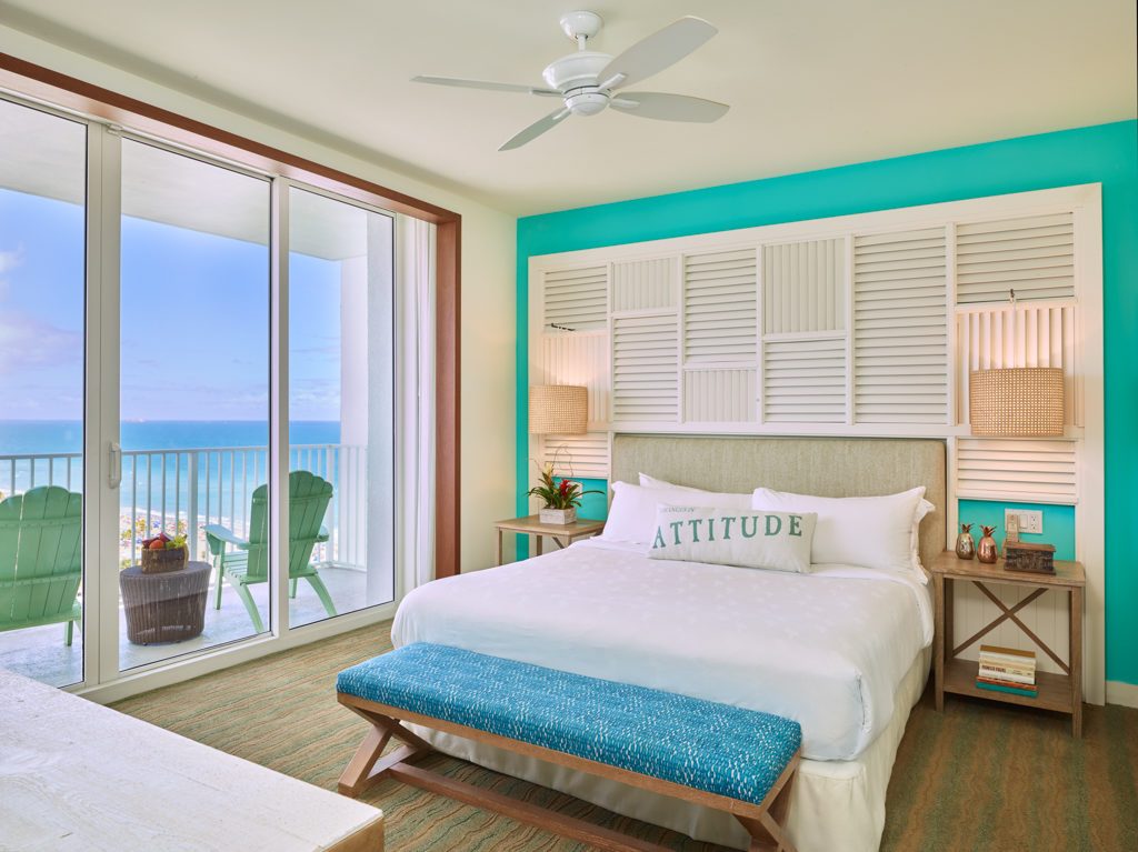 Room contemporary furnishings with a sea and sky color palette, one king bed, large window and balcony